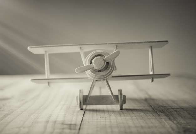 Aeroplano de madera del juguete en la tabla de madera en tono del vintage.