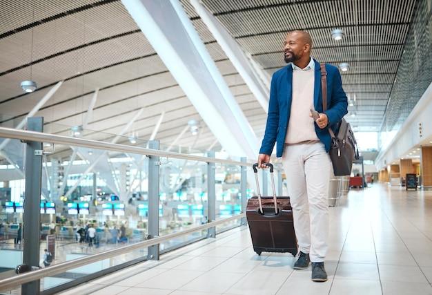 Aeroporto de viagem e bagagem com um homem negro de negócios andando em um terminal para uma maquete de gerente de sucesso global e voo com um ceo masculino em uma estação terminal para viagens internacionais de trabalho