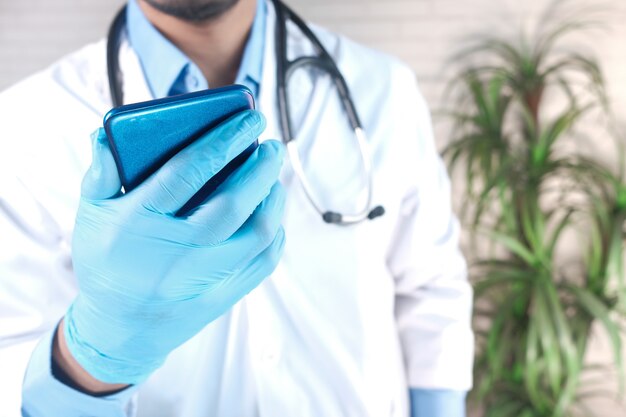 Ärzte geben schutzhandschuhe mit einem smartphone ab