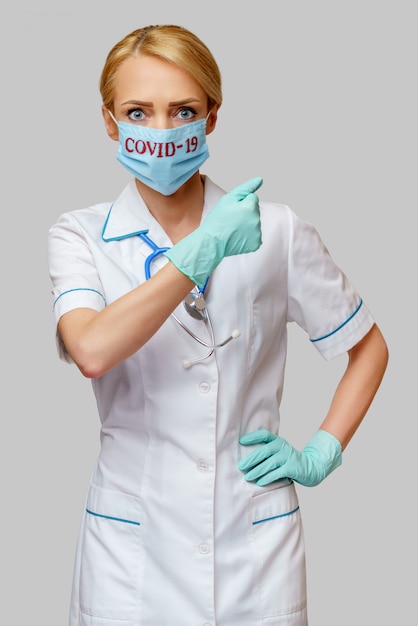 Ärztin der Krankenschwester mit Stethoskop, die Schutzmaske trägt
