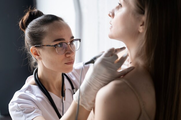 Ärztin diagnostiziert ein Melanom am Körper einer Patientin