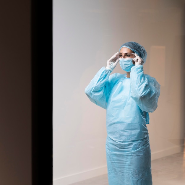 Foto Ärztin, die ihre gesichtsmaske aufsetzt
