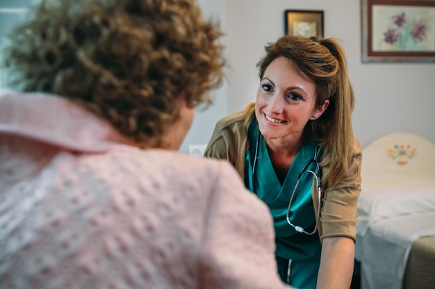 Ärztin im Gespräch mit älteren weiblichen Patienten im Rollstuhl