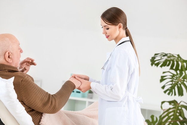 Foto Ärztin mit einem älteren mann mit parkinson-syndrom in der klinik