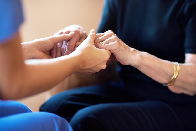 Foto Ärztliche ältere menschen und händchen haltend zur unterstützung des gesundheitswesens, medizinischer rat und empathie. professionelle krankenschwester, die älteren menschen hilft und sich um die altersvorsorge kümmert, unterschreibt gemeinsam in großaufnahme