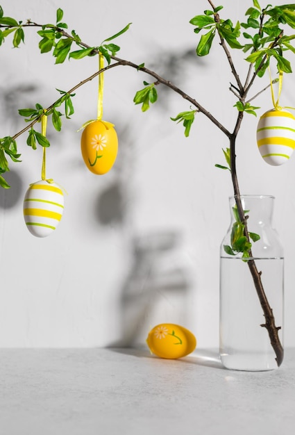 Äste mit Ostern bemalten Eiern auf grauem Hintergrund