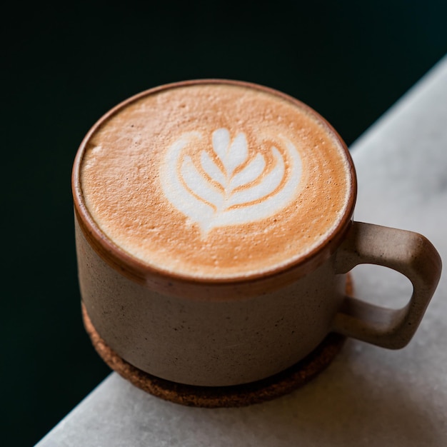 Foto Ästhetischer cappuccino-kaffee auf einem ästhetischen schwarz-weißen tisch