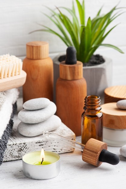 Ätherisches Öl in wiederverwendbaren Flaschen auf hölzernem Hintergrund. Natürliches Bio-Spa mit umweltfreundlicher Verpackung