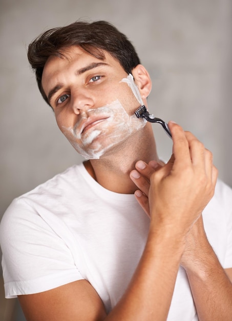 Afeitado de limpieza y retrato de hombre en el baño para el cuidado facial, bienestar y cosméticos en el hogar Cuidado de la piel y afeitado de persona masculina para el autocuidado de la higiene facial y depilación con maquinilla de afeitar