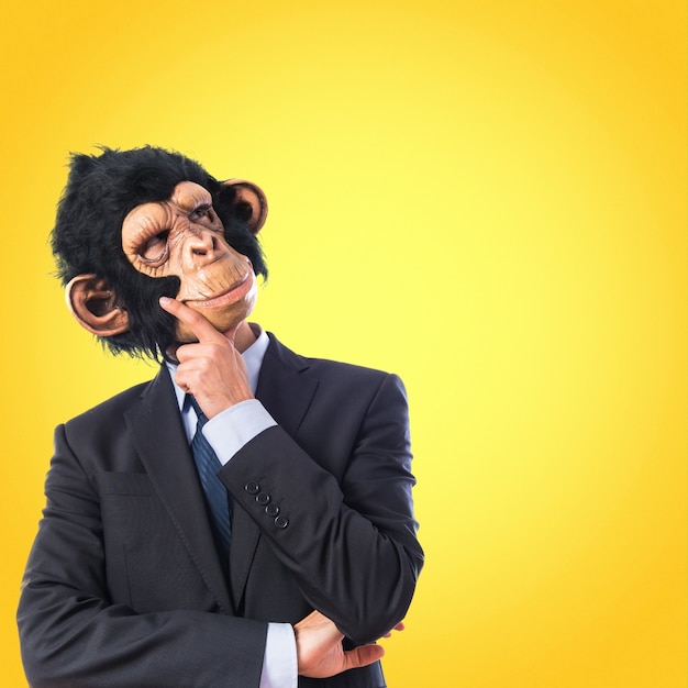 Affe Mann Denken über weißen Hintergrund auf bunten Hintergrund