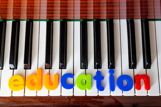 Afiche con la palabra educación Las letras están dispuestas en el primer plano del piano