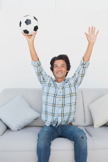 Foto aficionado al fútbol animando mientras ve la televisión