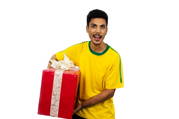 Aficionado al fútbol brasileño celebra con un regalo rojo aislado sobre fondo blanco.