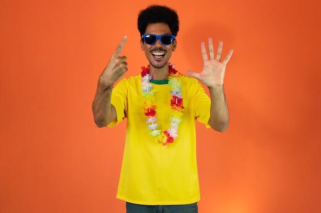 Aficionado al fútbol hombre negro hombre en camisa amarilla aislado sobre fondo naranja