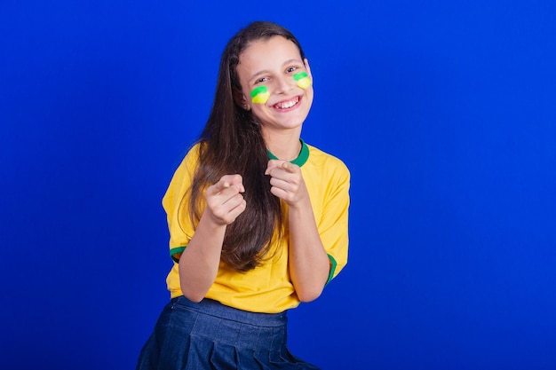 Aficionado al fútbol joven de Brasil apuntando a la cámara eligiéndote