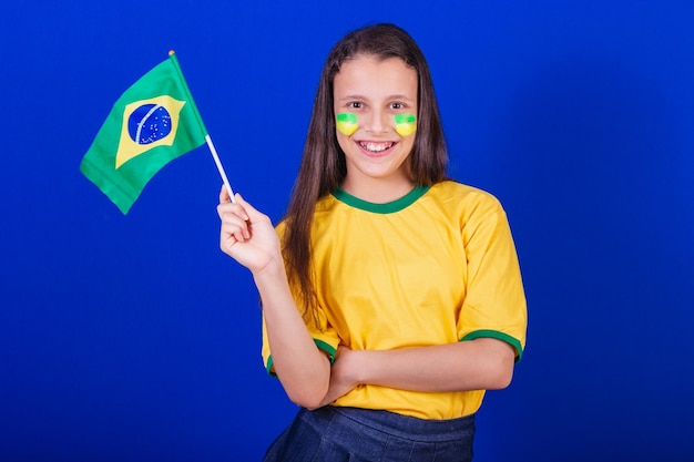 Aficionado al fútbol joven de Brasil sosteniendo la bandera de Brasil