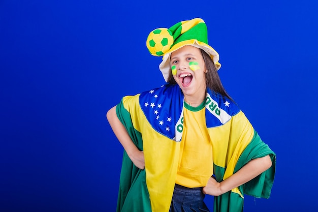 Aficionado al fútbol joven de Brasil vestido con sombrero y bandera