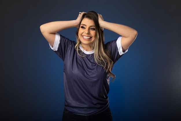 Aficionado al fútbol mujer animando a su club favorito y al equipo de fondo azul de la copa mundial