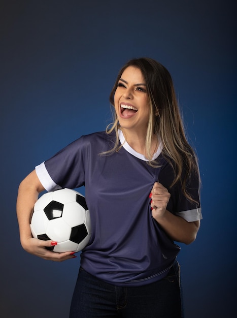 Aficionado al fútbol mujer animando a su club favorito y al equipo de fondo azul de la copa mundial