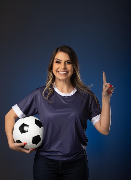 Aficionado al fútbol mujer animando a su club favorito y al equipo de fondo azul de la copa mundial