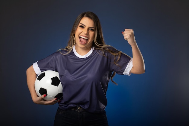 Foto aficionado al fútbol mujer animando a su club favorito y al equipo de fondo azul de la copa mundial