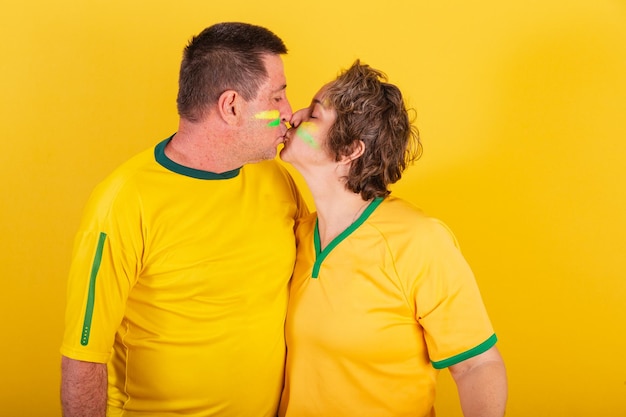 Aficionado al fútbol de pareja adulta de brasil besándose