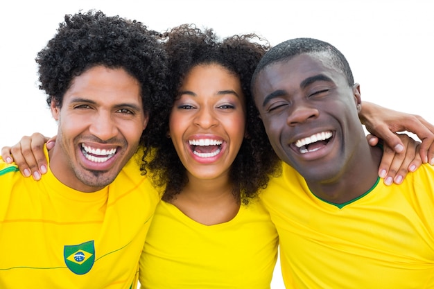 Aficionados al fútbol brasileños felices en amarillo sonriendo a la cámara