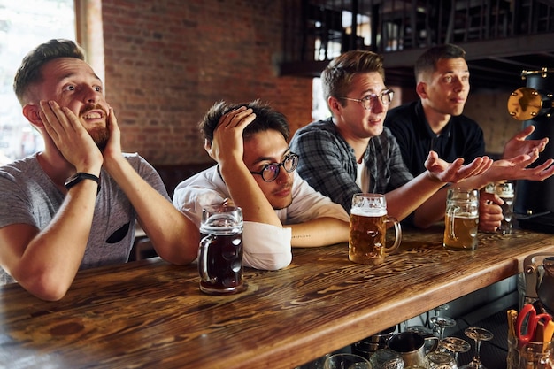 Aficionados al fútbol Gente con ropa informal sentada en el pub