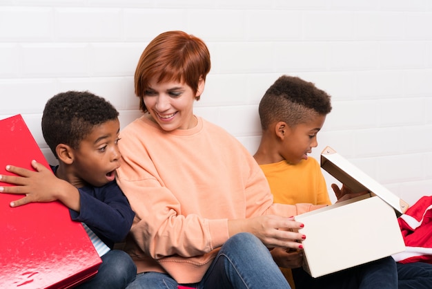 African American Kinder mit ihrer Mutter unter vielen Geschenken für Weihnachten und Neujahr