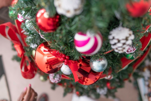 African American Nigerian Woman schmücken ihren Weihnachtsbaum für die festliche Weihnachtszeit