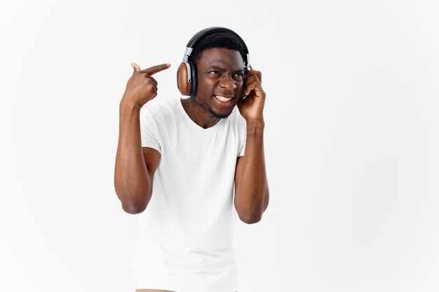 Africano americano con auriculares escuchando música emociones camiseta blanca foto de alta calidad