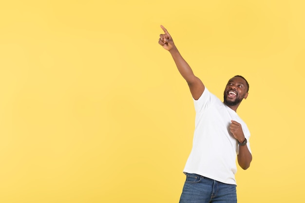 Africano apontando o dedo para cima perto do espaço vazio fundo amarelo