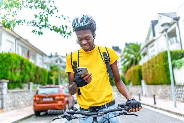 Africano feliz entregador usando telefone à procura de seu destino