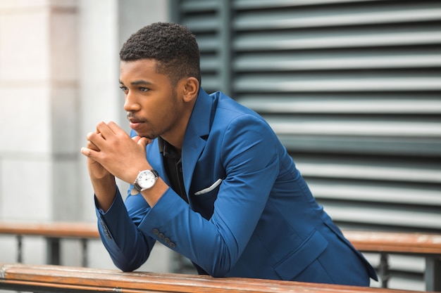 Africano jovem bonito com um casaco azul