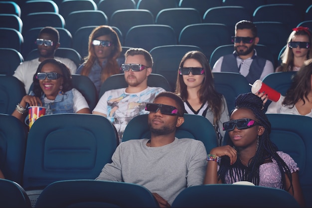 Los africanos y los caucásicos viendo la película en gafas 3d.