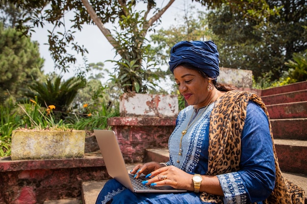 Afrikanerin arbeitet mit ihrem Laptop 50 Jahre alte Dame und Technologie