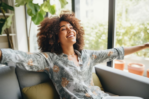 Foto afrikanerin feiert einen neuen job, während sie zu hause auf einer couch sitzt