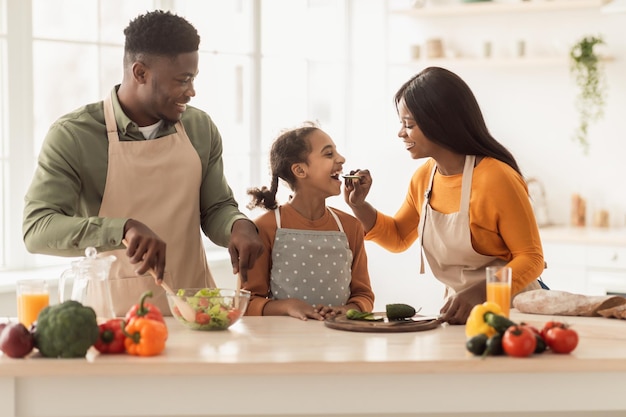 Afrikanische Familie, die Spaß daran hat, sich gegenseitig in der Küche zu füttern