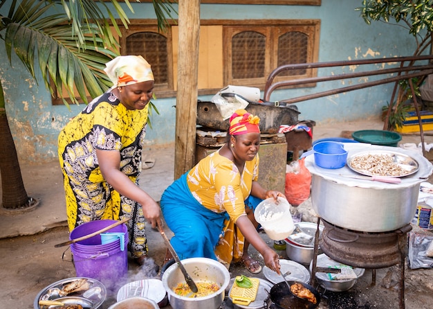 Afrikanische Frau, die traditionelles Essen auf der Straße kocht