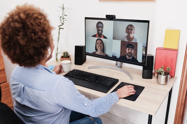 Afrikanische Frau, die Videoanruf mit ihren Kollegen unter Verwendung der Computer-App hat - Weichzeichner auf der rechten Hand