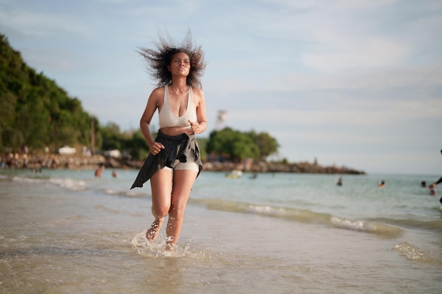 Afrikanische Frau im Sport-BH läuft am Strand für Outdoor-Training Portrait sexy asiatische afrikanische Dame bereitet sich auf Fitness am Strand vor