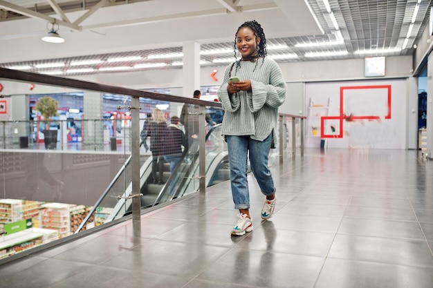 Foto afrikanische frau posierte in pullover und jeans im einkaufszentrum