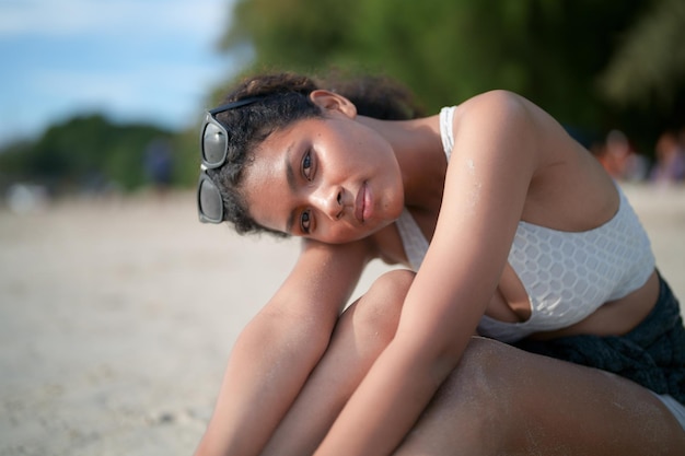 Afrikanische Frau sitzen am Strand Porträt sexy afrikanische Dame Reiseping und Entspannung im Sommer mit tropischer Natur