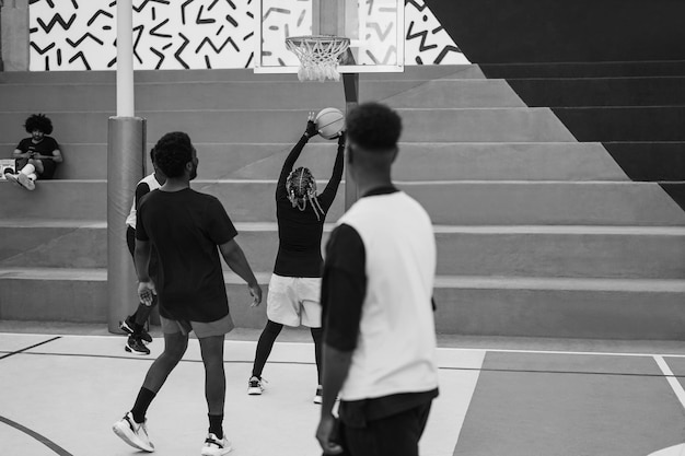 Foto afrikanische freunde spielen basketball im freien. weicher fokus auf den kopf eines mädchens. schwarz-weiß-bearbeitung