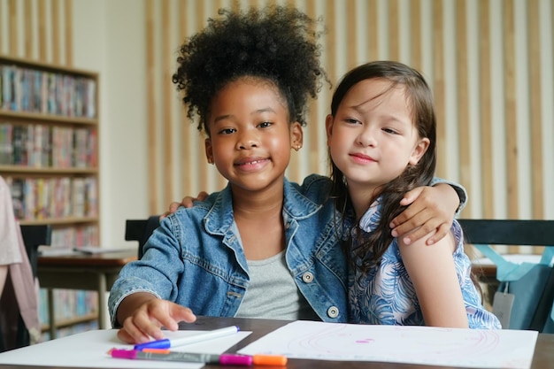 Afrikanische Kinder zeichnen und machen Hausaufgaben im Klassenzimmer junges Mädchen fröhliches lustiges Studium in der Schule