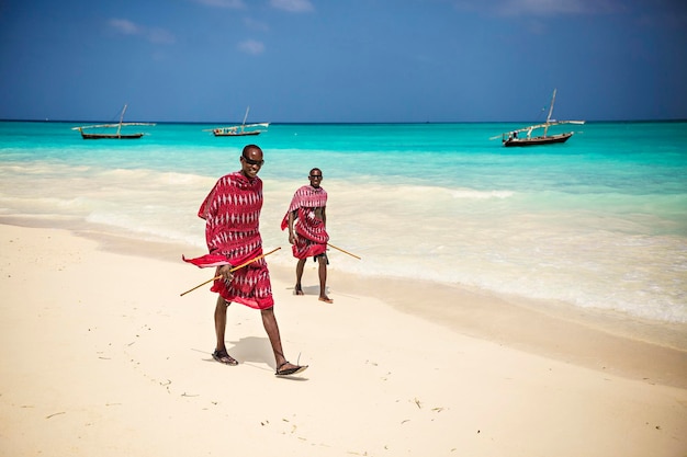 Afrikanische Masai Mann traditionell gekleidet am Strand von Nungwi Dorf, Sansibar, Tansania