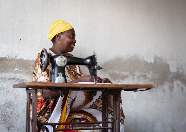 Afrikanische Schneiderin arbeitet an Nähmaschine