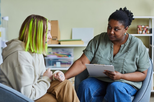 Afrikanische Schulpsychologin unterstützt traurige Teenagerin in ihrer schwierigen Situation in der Schule