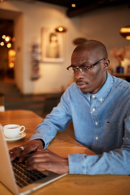 Afrikanischer Geschäftsmann, der im Cafe arbeitet