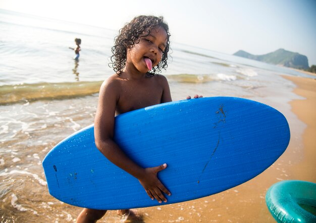 Afrikanischer kleiner Junge, der am Strand spielt